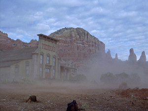 Johnny's first sight of Vienna's saloon emerging from a dust storm against a backdrop of mountains..